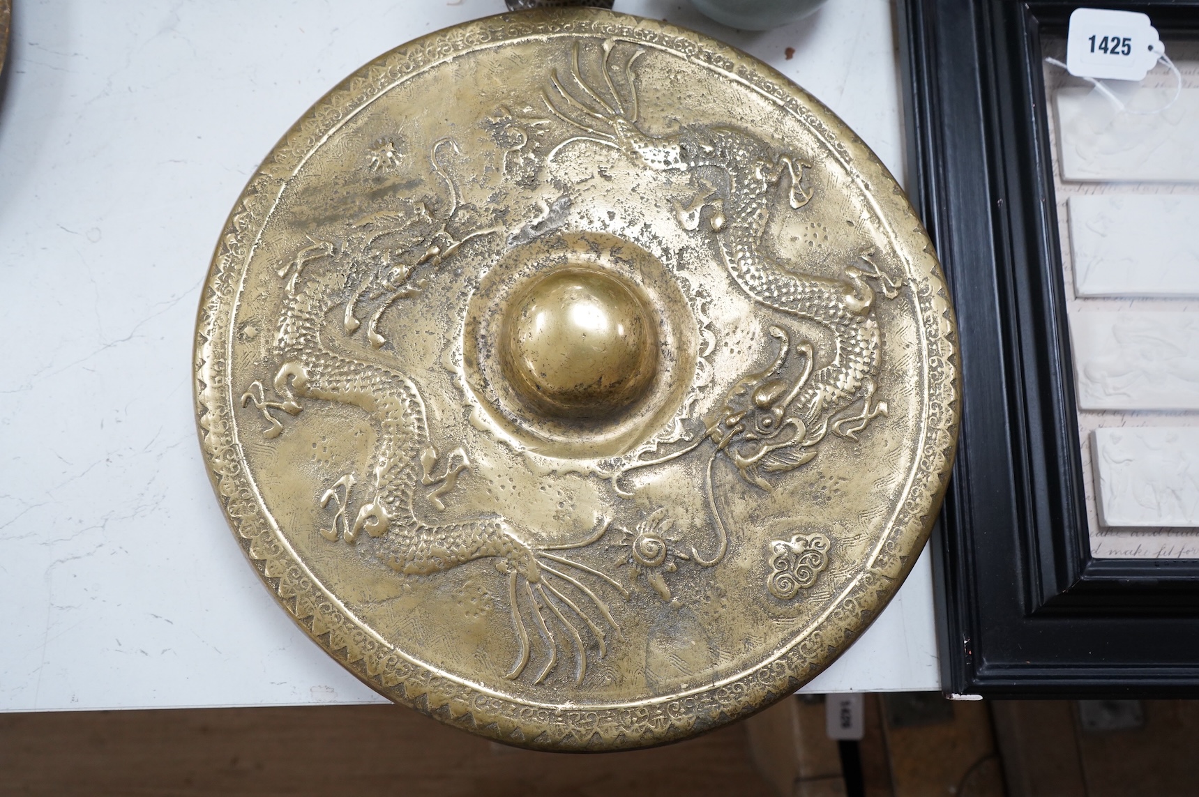 A Brunei bronze temple gong, decorated in relief with a three clawed dragon, 38cm in diameter
